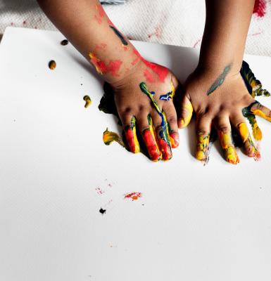 un par de manos infoamtiles con pintura sobre una superficie banca