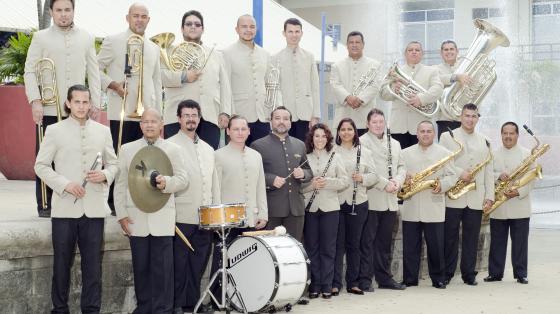 En la foto posan los músicos de la Banda de Conciertos de Puntarenas vestidos con sus guerreras color beige. Lucen muy elegantes y sonrientes junto a sus instrumentos.