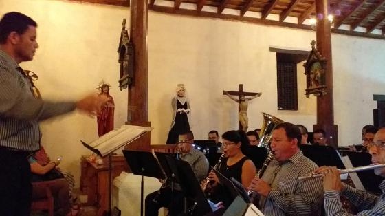 En la foto, del lado izquierdo se encuentra Ronald Estrada de perfil dirigiendo al ensamble de la Banda de Conciertos de Guanacaste, dentro de un templo católico.
