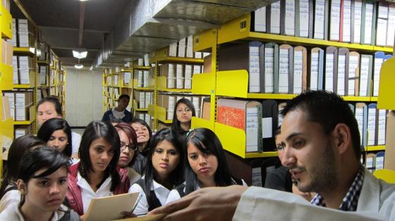 La visita a los depósitos es parte habitual del recorrido. Estudiantes observan un documento original durante una visita a un depósito.