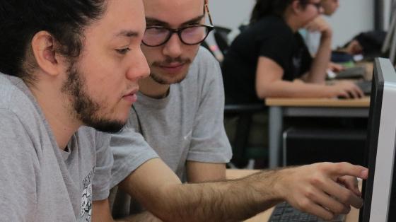 Dos jóvenes viendo una computadora 