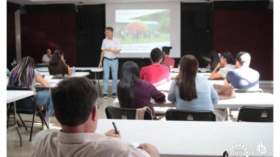 Taller de Registro de Marca Persona de pie explicando a un grupo de personas un tema en especifico