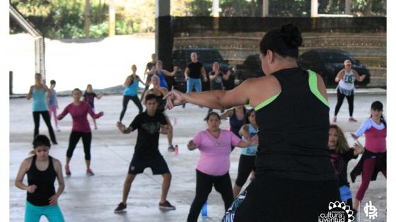 Personas realizando ejercicios bailables con la instructora
