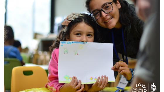 Niñas mostrando dibujo que realizaron