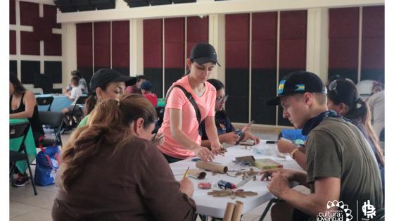 Personas trabajando en una mesa realizando actividades creativas