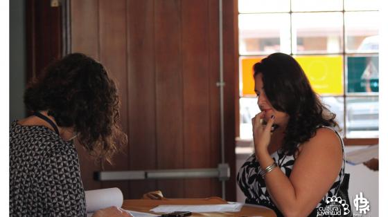 Taller virtual: Indicadores básicos de productividad Una persona frente a otra esperando una respuesta mientras una de ellas está buscando en un documento