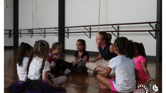 Niñas con su profesora conversando, todas ellas sentadas haciendo un circulo