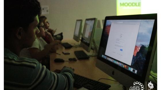 Taller Redes Sociales para emprendedores (metodología virtual) Jóvenes frente a pantallas de computadoras recibiendo lecciones