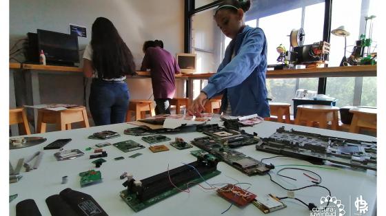 Niños realizando experimentos con una mesa llena de piezas