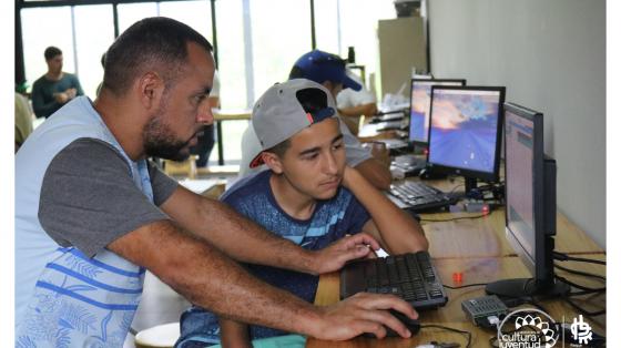 Matrícula de cursos virtuales del III Cuatrimestre 2020, Área de Diseño Un profesor explicándole a un joven un programa en la computadora