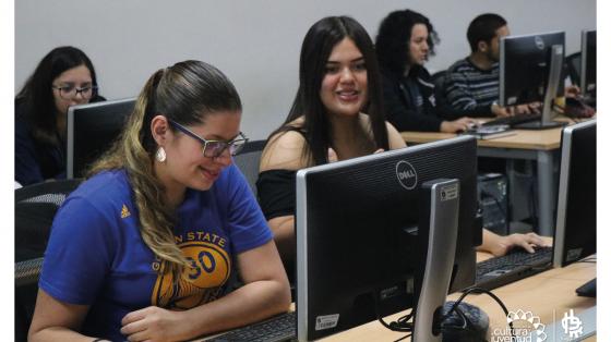 Dos jóvenes aprendiendo mientras están en un laboratorio de cómputo 