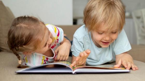 Estimulación a la lectura: niños de 3 a 4 años Un niño y una niña leyendo en el piso