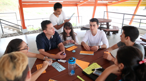 Jóvenes trabajando alrededor de una mesa 