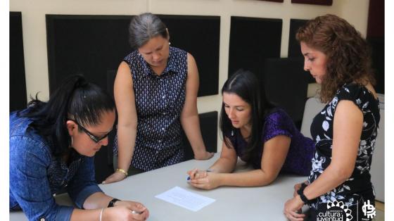 Cuatro personas revisando un documento en conjunto