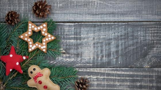 Esquina superior derecha de un árbol de navidad adornadoc on una esfera, una estrella y un muñequito