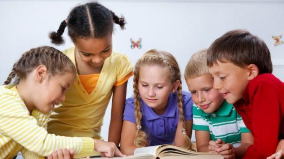 Grupo de niños leyendo en el piso