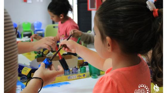 Niñas dibujando con pintura y pinceles