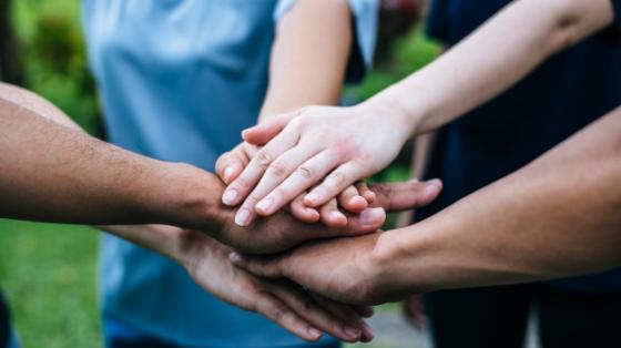 Equipo de trabajo, con las manos juntas