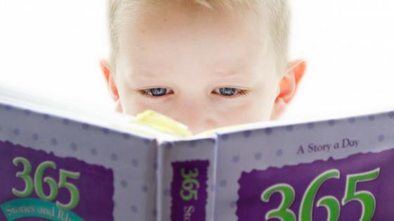 Niño leyendo un libro en primer plano.