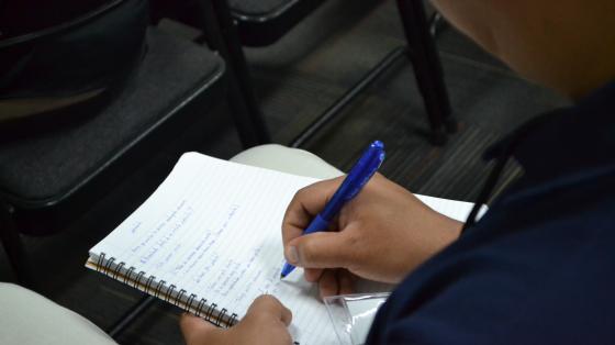 Charla: Cómo elaborar un curriculum vitae Persona tomando apuntes de cómo realizar correctamente un currriculum