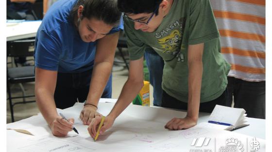 Charla: ¿Cómo establecer mis metas? Dos personas escribiendo en un papel las cosas más importantes