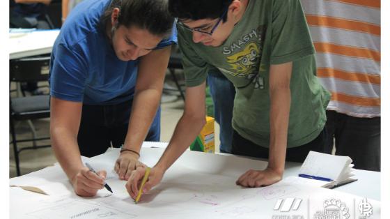 Dos personas escribiendo en un papel las cosas más importantes