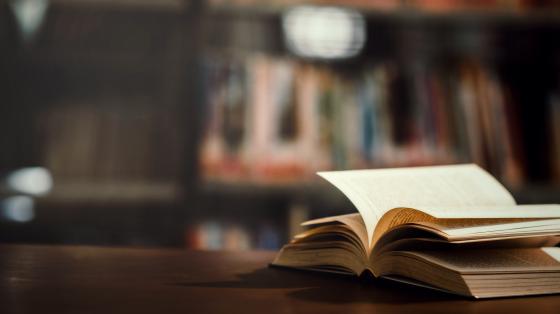 Libro abierto por la mitad sobre una mesa de madera. 