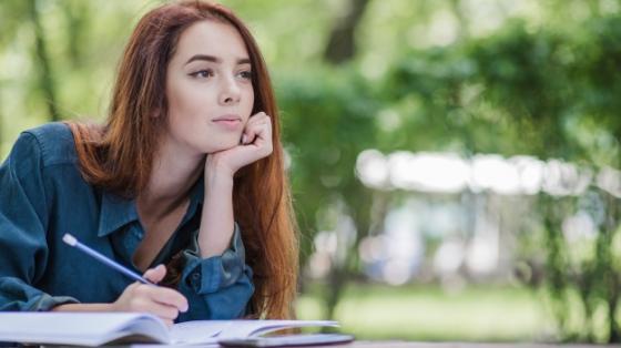 Mujer escribiendo en un parque. 