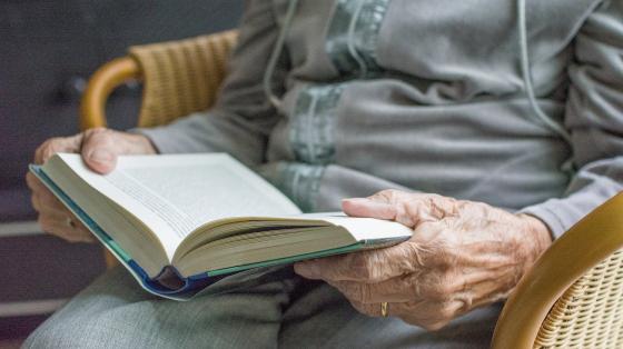 Adulta mayor leyendo un libro. 