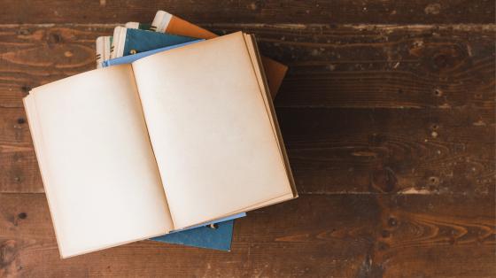 Conversatorio: Recopilación bibliográfica de leyendas paraiseñas Libro abierto por la mitad sobre una mesa de madera.