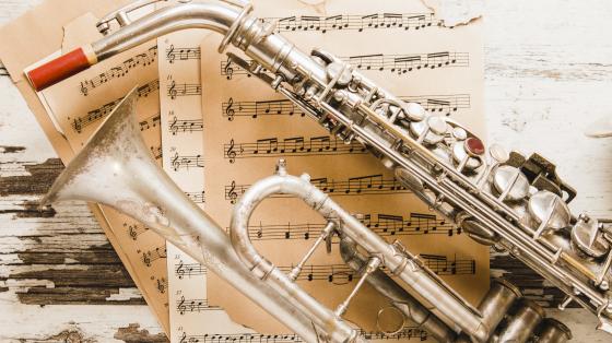 V Conversatorio de Música Costarricense: Jazz y música clásica Partituras musicales y un saxófon.