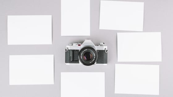 Actua: exposición de fotografías escritoras costarricenses de la artista Marlene Ramírez Fondo gris. Fotografías alrededor de una cámara fotográfica.
