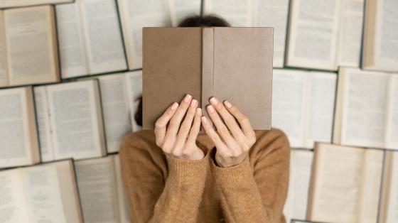 Recital con la Asociación Costarricense de Escritoras en el marco del Día Internacional de la Eliminación de la Violencia contra la Mujeres Fondo de libros abiertos. Persona sosteniendo el libro tapando su cara.