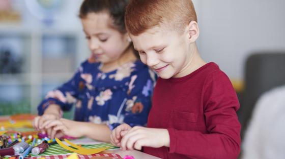 Vacaciones en la biblioteca Dos niños haciendo manualidades.