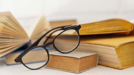 Taller para emprendedores Fondo de libros y en primera plana unos anteojos.
