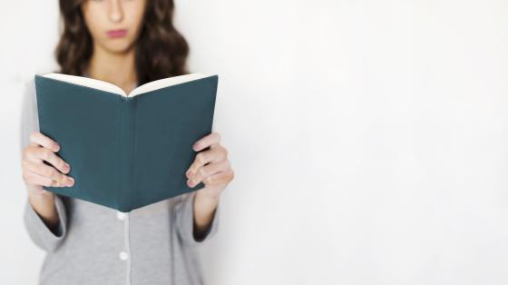 Conversatorio "Las mujeres y su legado en la literatura costarricense" Mujer sosteniendo un libro.