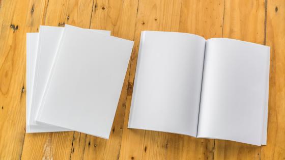Presentación del último número de la Revista Cultura Sobre mesa de madera. Libros desde vista superior.