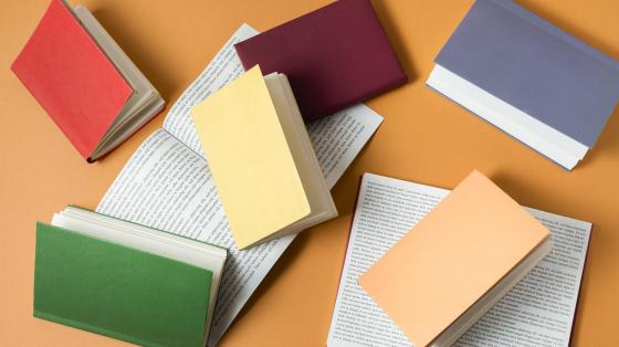 Presentación del libro "Los ojos del antifaz" de Adriano Corrales Composición de libros de colores.
