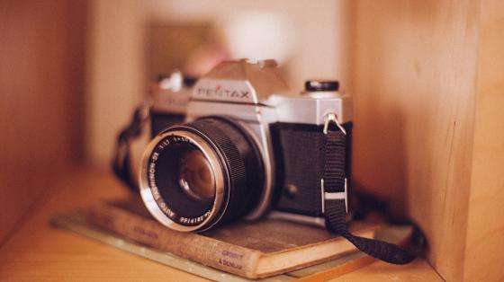 Exposición de fotografías "Aves Tikas" Una cámara fotográfica sobre 2 libros