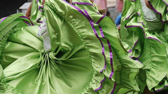 Presentación del Ballet Folklórico Huitzillin Varias personas con faldas folclóricas en movimiento