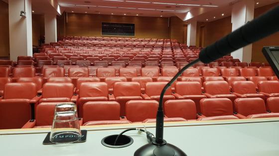 Conferencia "Poder, curas, parroquias y vida cotidiana: Las prácticas en México y Costa Rica” Un micrófono y de fondo unos asientos