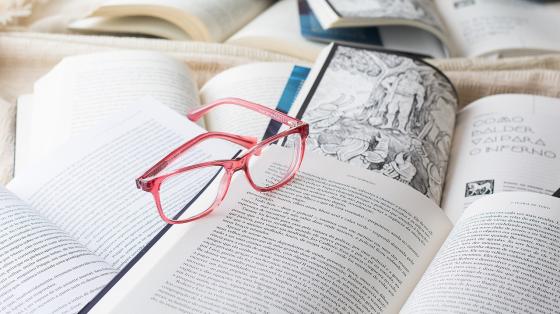 Maternidades: recital y exhibición Varios libros abiertos y unos lentes
