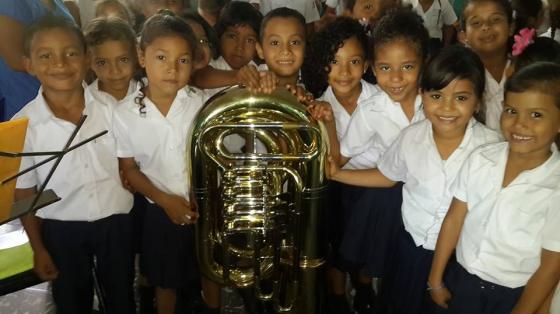 Concierto Educativo "Escuela de Bolsón", Santa Cruz | Banda de Conciertos de Guanacaste Niños y niñas sonriendo y rodeando a una Tuba