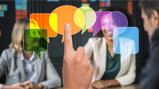 Varias personas reunidas conversando de fondo y unos cuadros de diálogo de diálogo en primer plano