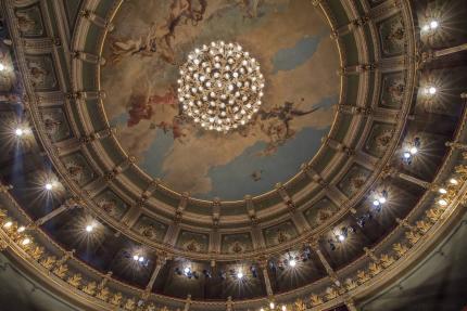 Fotografía: Detalle de lámpara y pinturas del cielorraso, en el Teatro Nacional de Costa Rica, edificio patrimonio histórico arquitectónico del país. Foto: Adela Marín