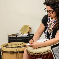 Joven tomando notas sobre instrumento de percusión