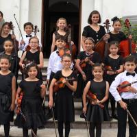 Niños del Instituto Nacional de la Música sosteniendo violínes.