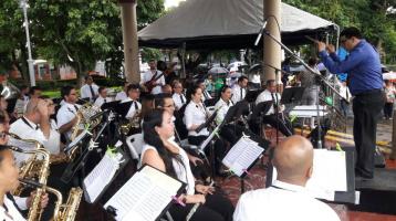 Los músicos de la Banda de Conciertos de Limón tocan en el parque de Limón dirigidos por Alberto Portuguez. Suave luz de día.
