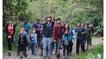 Personas detrás de un guía realizando avistamiento de especies en el Parque