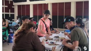 Personas trabajando en una mesa realizando actividades creativas